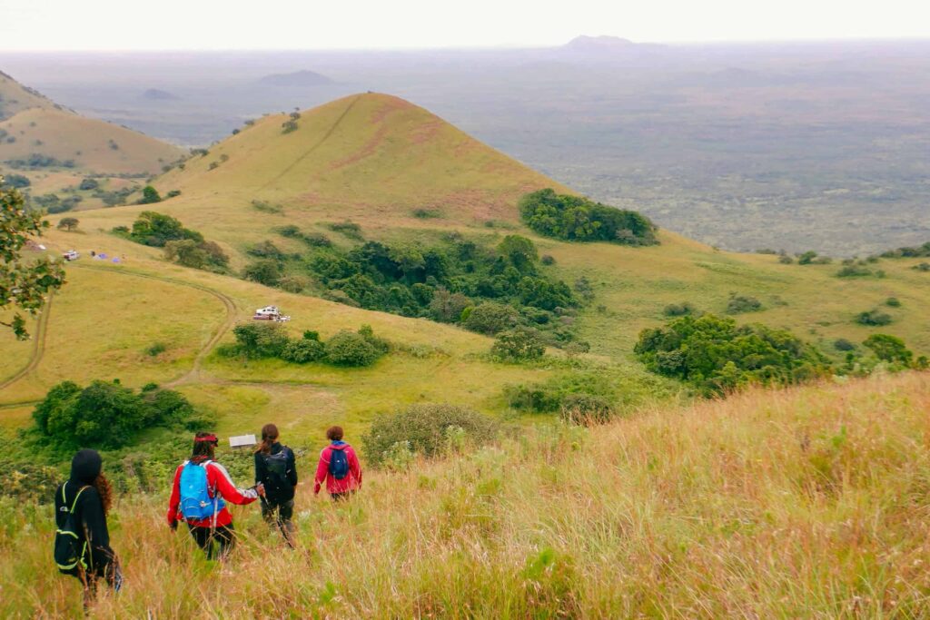 Rear view of a group of hikers at the panoramic mountain landscapes at Chyulu Hills, Chyulu Hills National Park, Kenya
